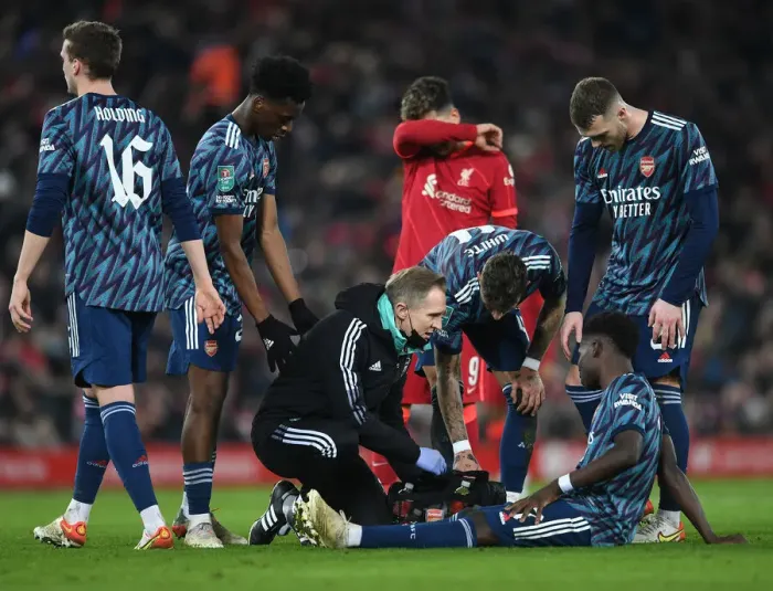 Framed Print : Arsenal's Bukayo Saka Receives Treatment from Physio During Liverpool vs Arsenal Carabao Cup Semi-Final