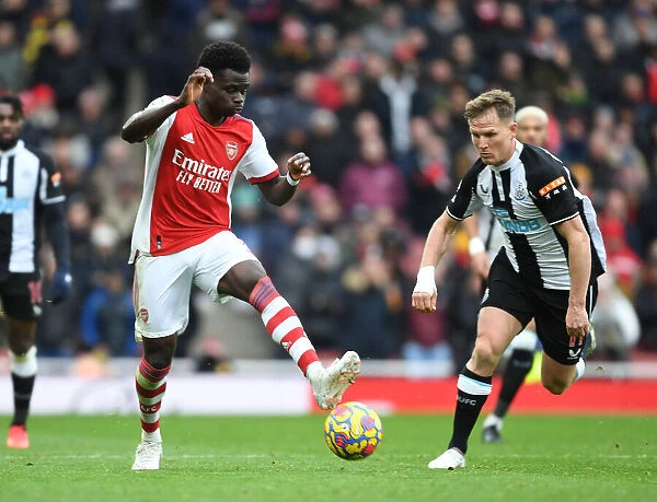 Arsenal's Bukayo Saka Takes on Newcastle's Matt Ritchie in Premier League Clash