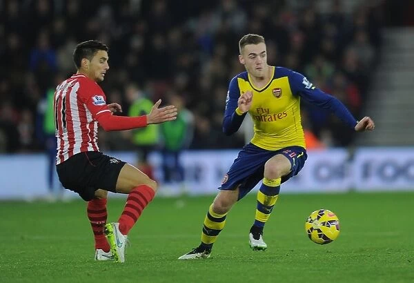 Arsenal's Calum Chambers Outmaneuvers Southampton's Dusan Tadic in Premier League Clash