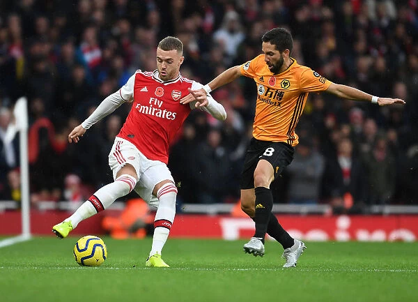 Arsenal's Calum Chambers Outmaneuvers Wolves Joao Moutinho in Premier League Clash