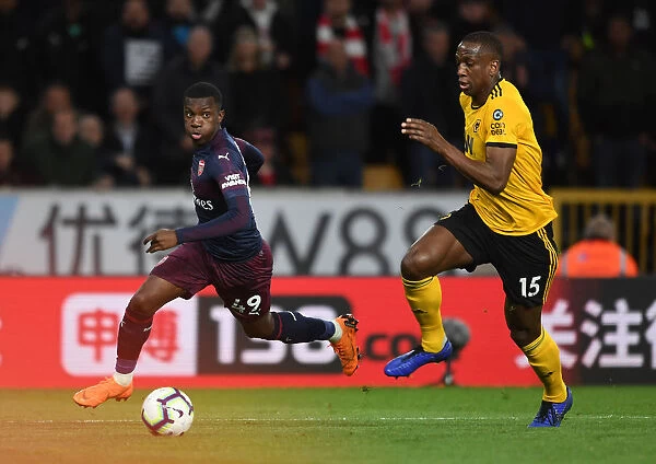 Arsenal's Eddie Nketiah Clashes with Wolves Willy Boly in Intense Premier League Showdown (2018-19)