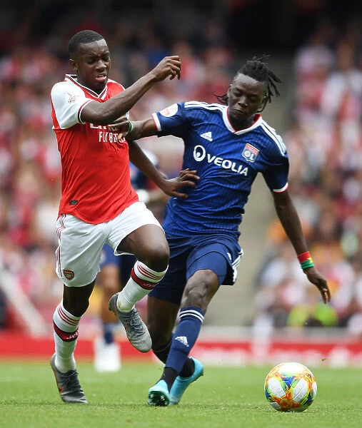 Arsenal's Eddie Nketiah Outmaneuvers Lyon's Bertrand Traore in Emirates Cup Clash
