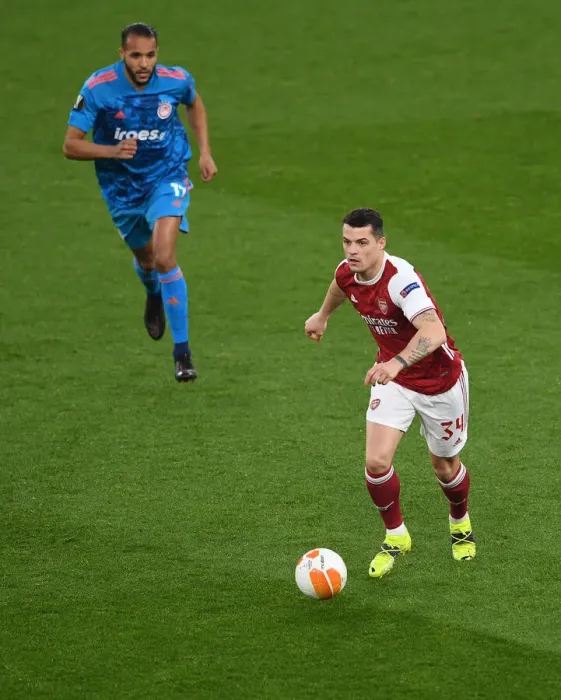 Framed Print : Arsenal's Granit Xhaka in UEFA Europa League: A Lone Warrior Amidst Empty Seats vs. Olympiacos