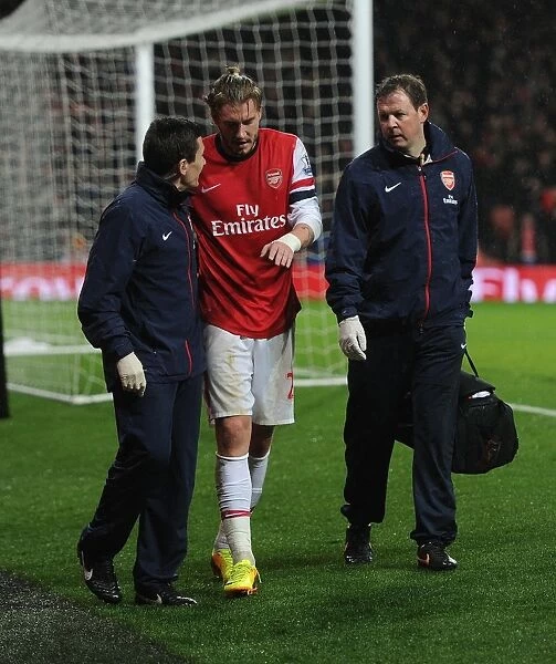Arsenal's Injured Nicklas Bendtner Receives Treatment from Medical Team during Arsenal v Cardiff City