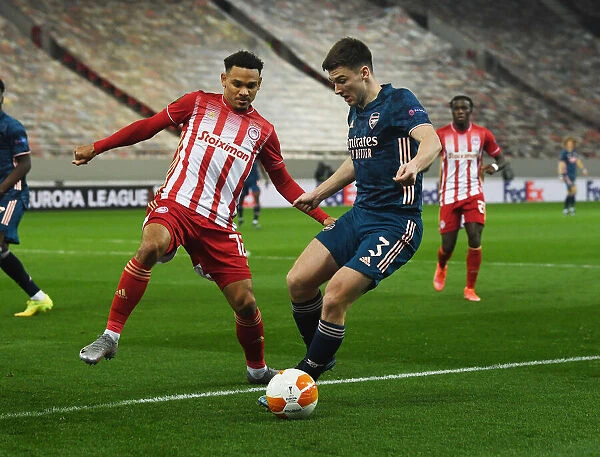 Arsenal's Kieran Tierney Clashes with Olympiacos Kenny Lala in Empty Europa League Stadium