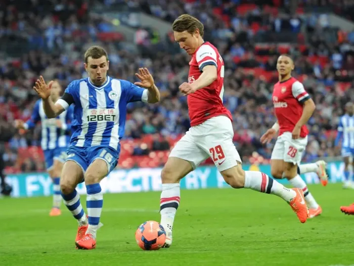 Framed Print : Arsenal's Kim Kallstrom Faces Off Against Wigan's James McArthur in FA Cup Semi-Final Showdown Framed Print : Arsenal's Kim Kallstrom Faces Off Against Wigan's James McArthur in FA Cup Semi-Final Showdown