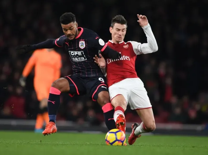 Framed Print : Arsenal's Koscielny Faces Off Against Huddersfield's Kachunga in Premier League Clash Framed Print : Arsenal's Koscielny Faces Off Against Huddersfield's Kachunga in Premier League Clash