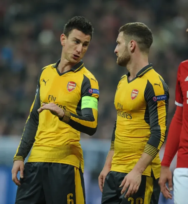 Framed Print : Arsenal's Koscielny and Mustafi Go Head-to-Head Against Bayern Munich in Champions League Clash