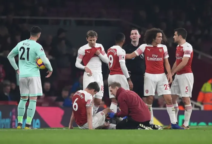 Framed Print : Arsenal's Koscielny Receives Treatment from Physio Jordan Reece during Arsenal v Bournemouth Match