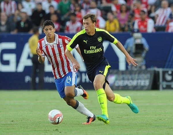 Arsenal's Krystian Bielik Faces Off Against Angel Zaldivar of Chivas in Pre-Season Clash