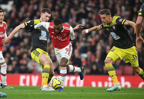 Arsenal's Lacazette Clashes with Southampton's Hojbjerg and Bednarek during the 2019-20 Premier League Match