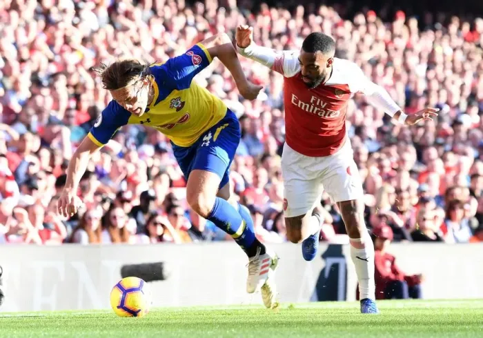 Framed Print : Arsenal's Lacazette Clashes with Southampton's Vestergaard in Premier League Showdown