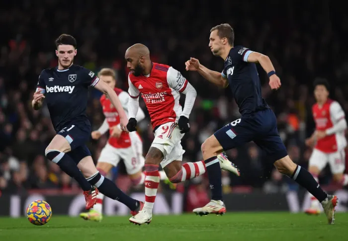 Framed Print : Arsenal's Lacazette Outmaneuvers Rice and Soucek in Intense Arsenal v West Ham United Clash (2021-22)