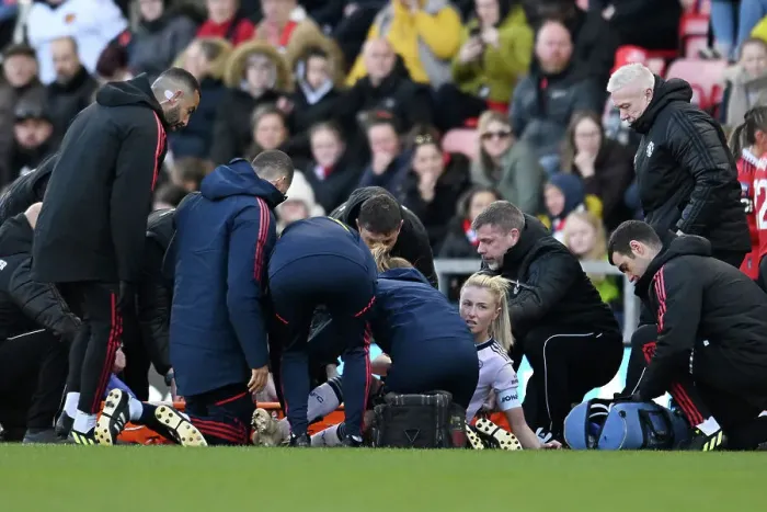 Framed Print : Arsenal's Leah Williamson Receives Medical Attention During Manchester United vs Arsenal Women's Super League Match