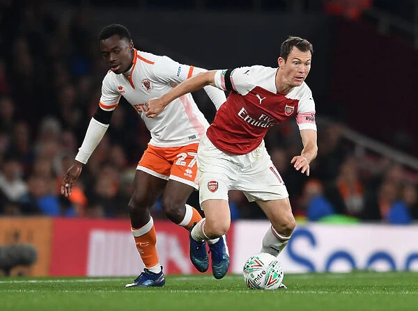 Arsenal's Lichtsteiner Clashes with Blackpool's Bola in Carabao Cup Showdown