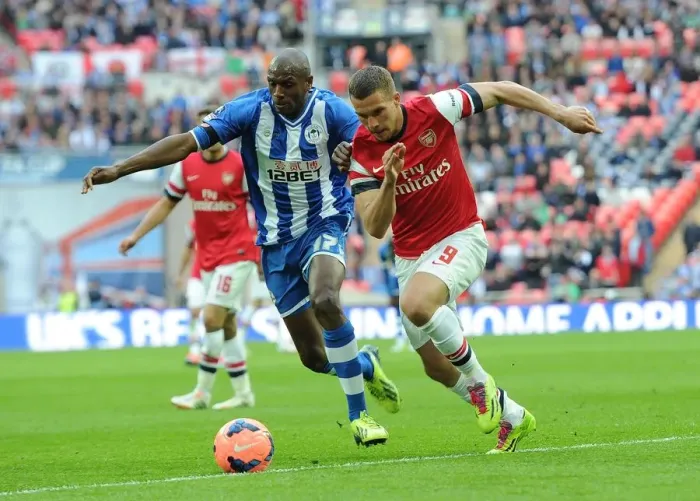 Framed Print : Arsenal's Lukas Podolski Faces Off Against Wigan's Emerson Boyce in FA Cup Semi-Final Showdown Framed Print : Arsenal's Lukas Podolski Faces Off Against Wigan's Emerson Boyce in FA Cup Semi-Final Showdown