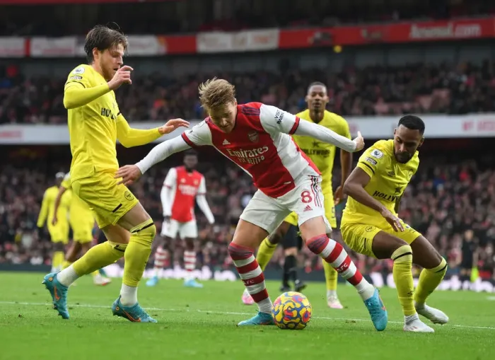 Framed Print : Arsenal's Martin Odegaard Clashes with Brentford's Mathias Jensen and Rico Henry during the Premier League Match Framed Print : Arsenal's Martin Odegaard Clashes with Brentford's Mathias Jensen and Rico Henry during the Premier League Match