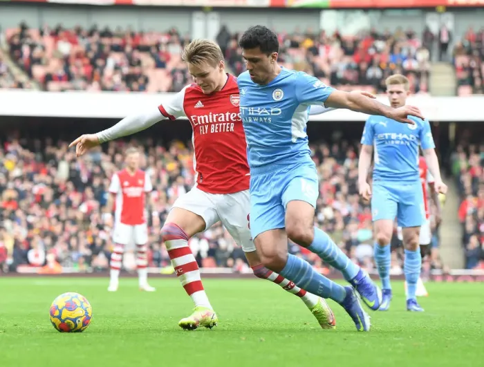 Framed Print : Arsenal's Martin Odegaard Clashes with Manchester City's Rodri: A Premier League Showdown at Emirates Stadium