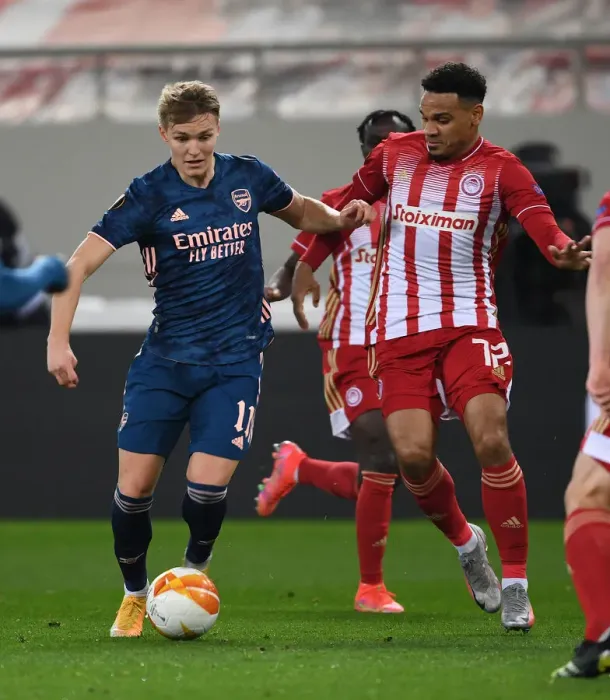 Framed Print : Arsenal's Martin Odegaard Clashes with Olympiacos Kenny Lala in UEFA Europa League Match Amidst Empty Stands Framed Print : Arsenal's Martin Odegaard Clashes with Olympiacos Kenny Lala in UEFA Europa League Match Amidst Empty Stands