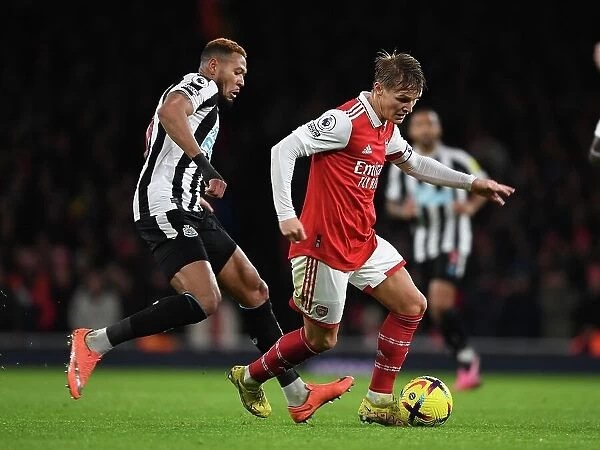 Arsenal's Martin Odegaard Outmaneuvers Newcastle's Joelinton in Premier League Clash