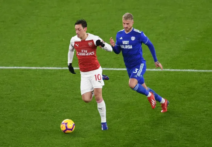Framed Print : Arsenal's Mesut Ozil Clashes with Cardiff's Joe Bennett in Premier League Showdown