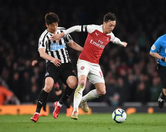 Framed Print : Arsenal's Mesut Ozil Clashes with Newcastle's Ki Sung-Yueng in Premier League Showdown
