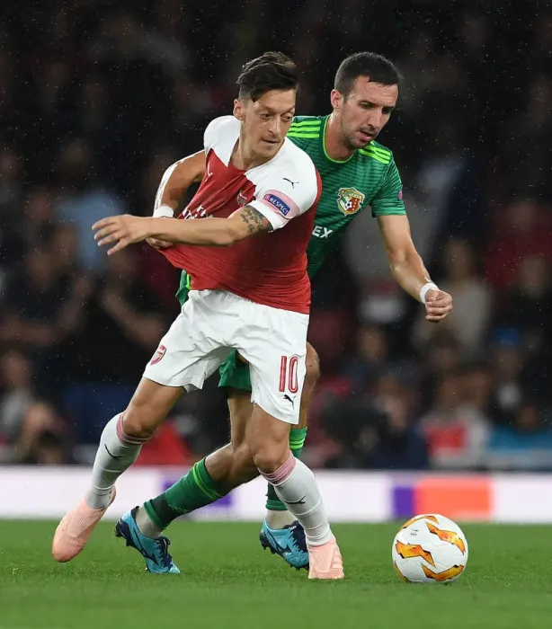 Framed Print : Arsenal's Mesut Ozil Clashes with Vyacheslav Sharpar of Vorskla Poltava in Europa League Match