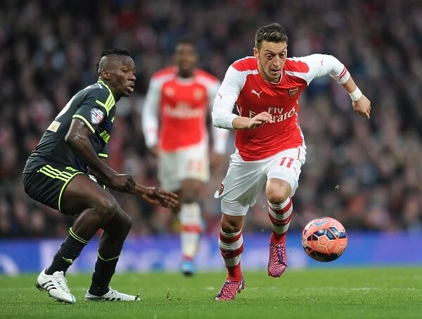 Arsenal's Mesut Ozil Outmaneuvers Middlesbrough's Albert Adomah in FA Cup Fifth Round Clash