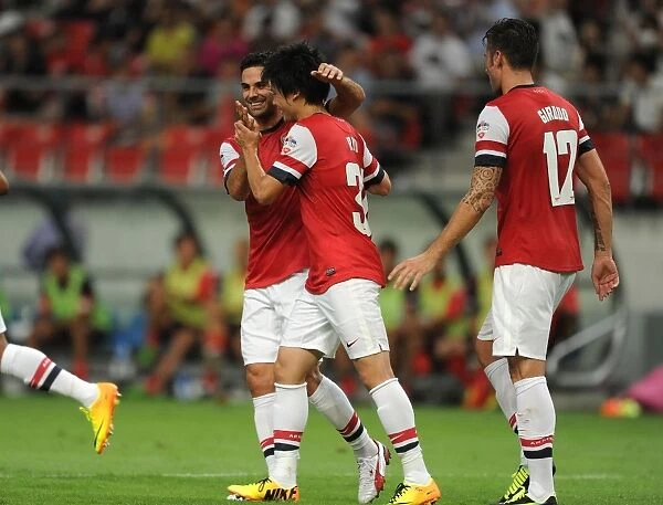 Arsenal's Miyaichi, Arteta, and Giroud Celebrate Goals Against Nagoya Grampus in 2013