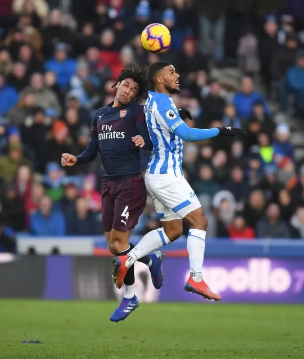Framed Print : Arsenal's Mo Elneny Faces Off Against Huddersfield's Elias Kachunga in Premier League Clash