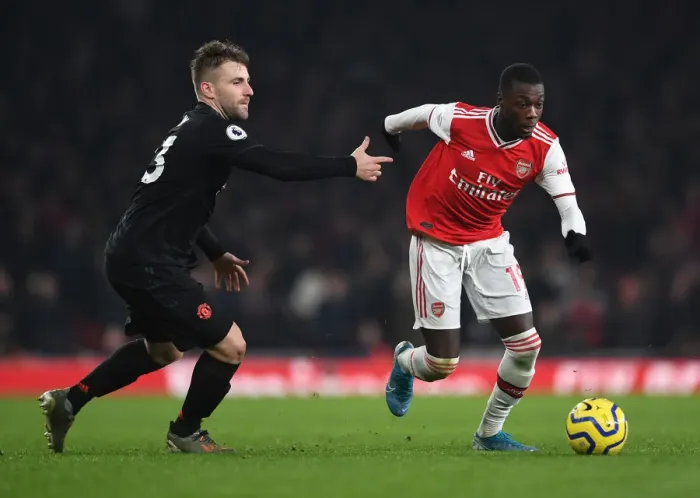 Framed Print : Arsenal's Nicolas Pepe Clashes with Manchester United's Luke Shaw in Premier League Showdown Framed Print : Arsenal's Nicolas Pepe Clashes with Manchester United's Luke Shaw in Premier League Showdown