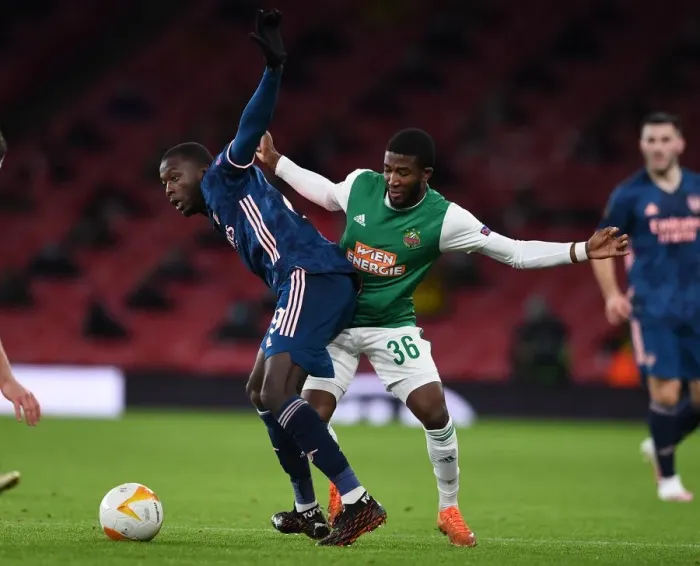 Framed Print : Arsenal's Nicolas Pepe Clashes with Rapid Wien's Kelvin Arase in Europa League Showdown