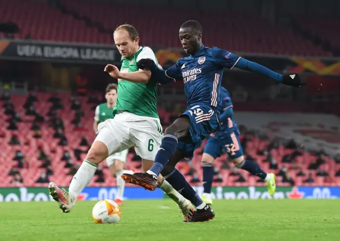 Framed Print : Arsenal's Nicolas Pepe Goes Head-to-Head with Rapid Wien's Mario Sonnleitner in Empty Emirates Stadium - UEFA Europa League 2020-21