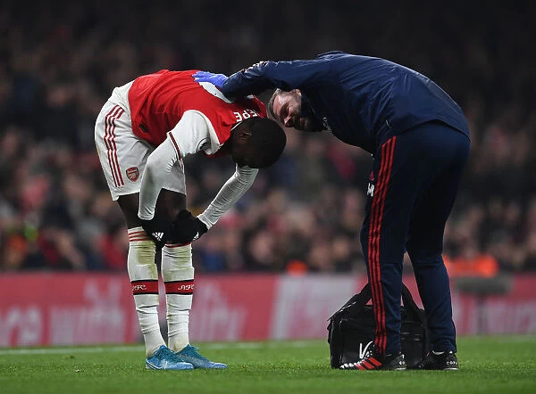 Arsenal's Nicolas Pepe Receives Treatment from Physio during Arsenal v Manchester United (2019-20)