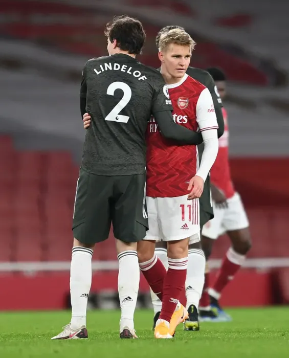 Framed Print : Arsenal's Odegaard Embraces Lindelof Amid Empty Emirates Stadium - Arsenal vs Manchester United, 2021