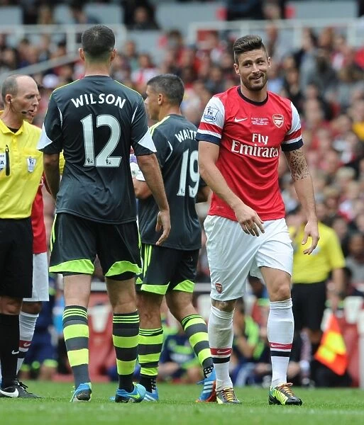 Arsenal's Olivier Giroud Engages in a Chat with Stoke City's Marc Wilson During the 2013-14 Premier League Match
