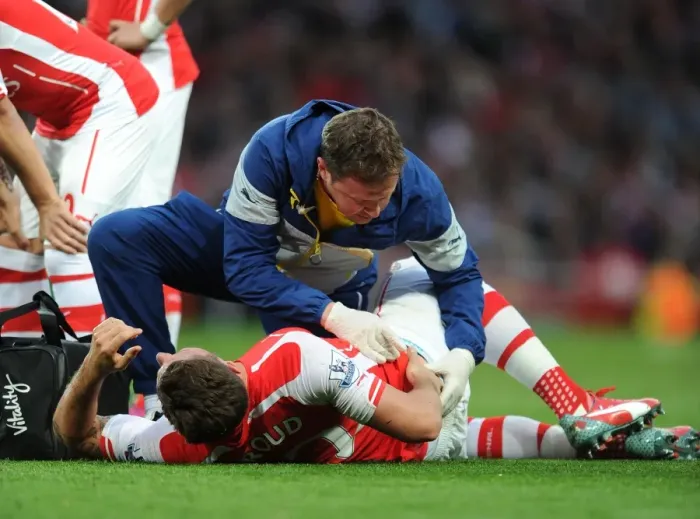 Framed Print : Arsenal's Olivier Giroud Receives Medical Attention from Physio Colin Lewin during Swansea City Match (2015)