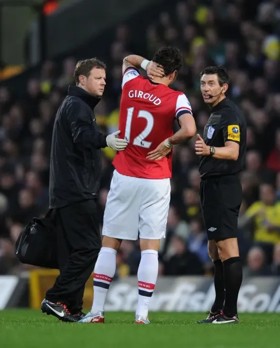 Framed Print : Arsenal's Olivier Giroud Receives Treatment from Physio Amidst Heated Norwich City Clash (2012-13)