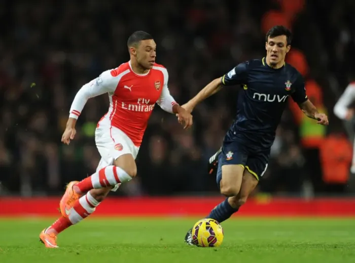 Framed Print : Arsenal's Oxlade-Chamberlain Clashes with Southampton's Cork in Premier League Showdown
