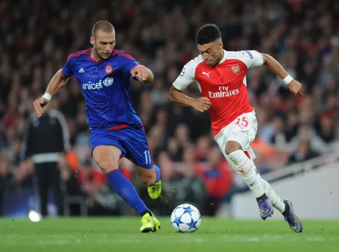 Framed Print : Arsenal's Oxlade-Chamberlain Goes Head-to-Head with Olympiacos Kasami