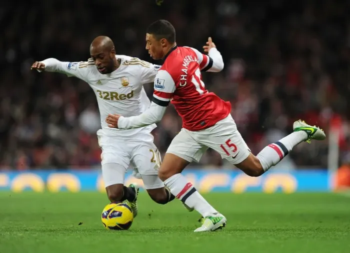 Framed Print : Arsenal's Oxlade-Chamberlain vs. Swansea's Tiendalli: A Premier League Battle