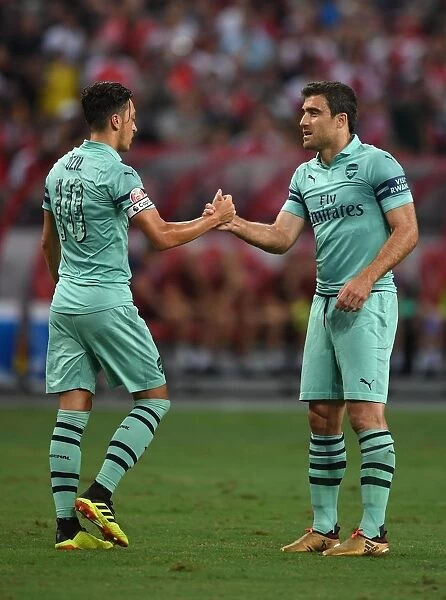 Arsenal's Ozil and Sokratis: Unity in Victory - Celebrating a Goal Against Paris Saint-Germain in the 2018 International Champions Cup (Singapore)