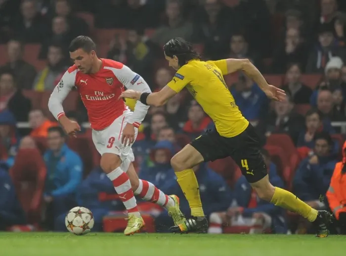 Framed Print : Arsenal's Podolski Clashes with Dortmund's Subotic in Champions League Showdown
