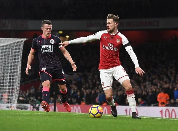 Arsenal's Ramsey Battles Huddersfield's Hogg in Premier League Clash