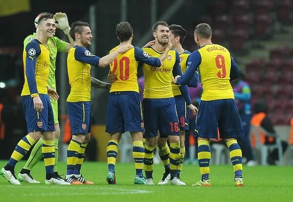 Arsenal's Ramsey, Debuchy, Flamini, Podolski, and Chambers Celebrate Goals Against Galatasaray in Champions League