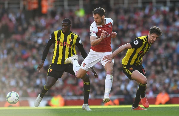 Arsenal's Ramsey Fends Off Doucoure and Cathcart Pressure During Arsenal v Watford Match