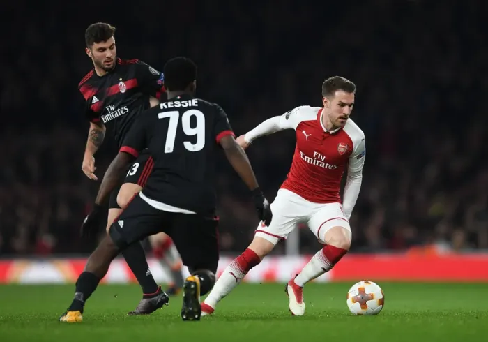 Framed Print : Arsenal's Ramsey Stands Firm Against Milan's Cutrone and Kessie in Europa League Showdown Framed Print : Arsenal's Ramsey Stands Firm Against Milan's Cutrone and Kessie in Europa League Showdown
