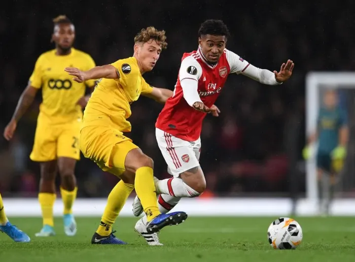 Framed Print : Arsenal's Reiss Nelson Clashes with Standard Liege's Mergim Vojvoda in Europa League Showdown