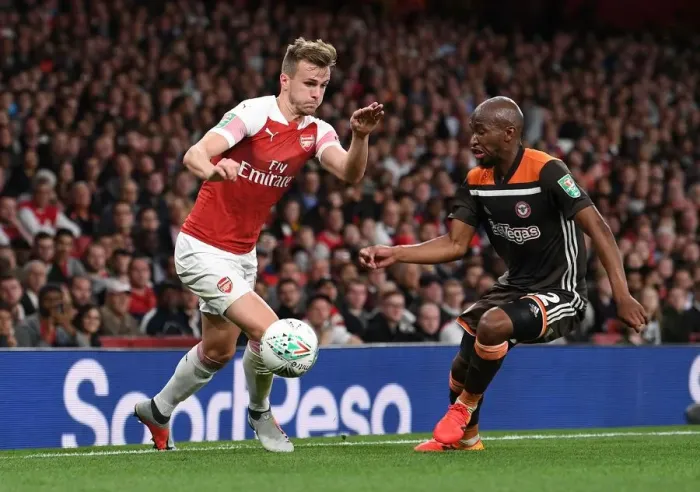 Framed Print : Arsenal's Rob Holding Clashes with Brentford's Moses Odubajo in Carabao Cup Showdown