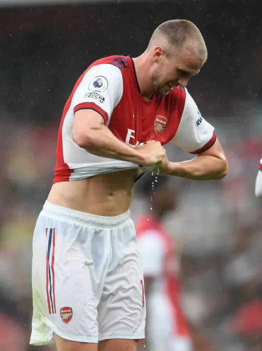 Framed Print : Arsenal's Rob Holding Rings Out Drenched Shirt in Heavy Premier League Rainfall (2021-22)